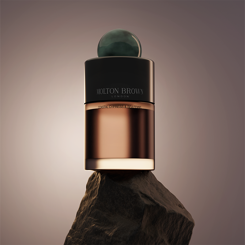 A bottle of Molton Brown perfume placed on a rock