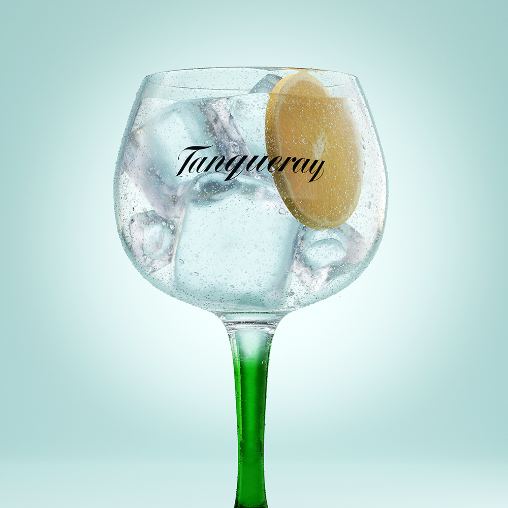 A cold condensed glass of Tanqueray Gin and Tonic and a slice of lemon